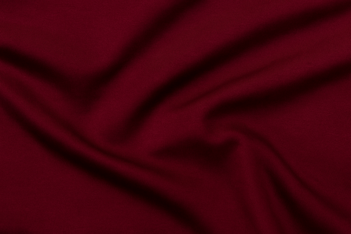 Close-up of burgundy bamboo jersey fabric, smooth, hypoallergenic, and naturally sustainable.