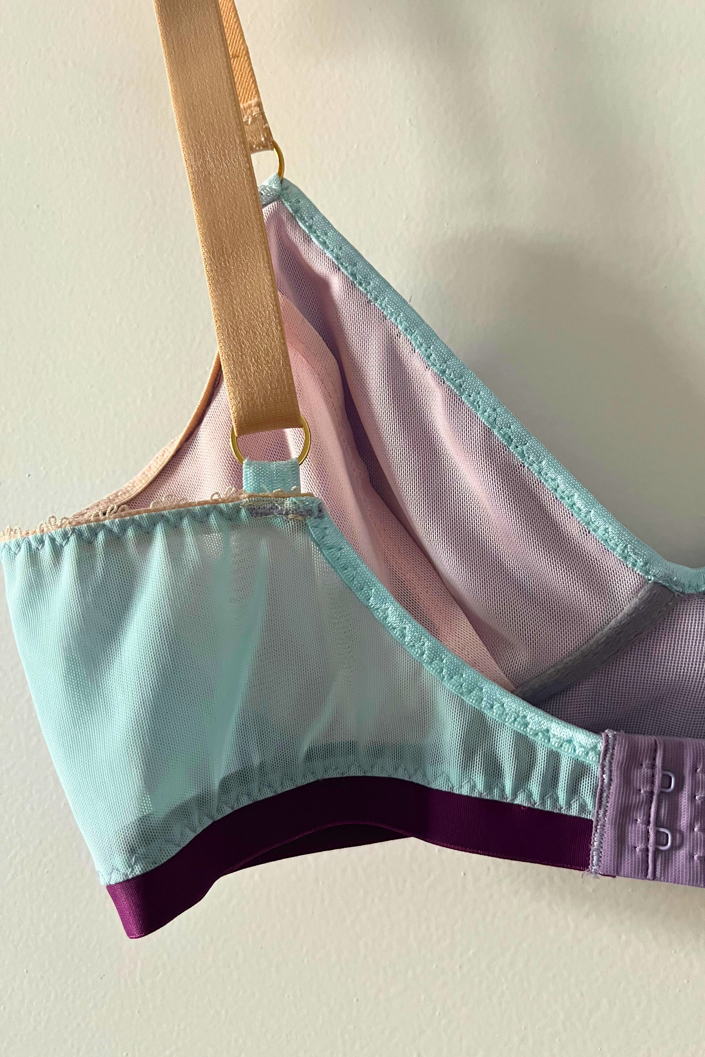 angled close-up of the lilac and aqua v-neck bralette, showing the colour-block design, v-shaped neckline and soft cotton jersey cups.