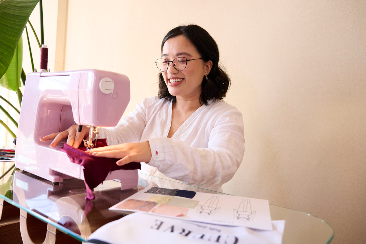 Aileen the founder of Cuurve at her sewing machine, designing 