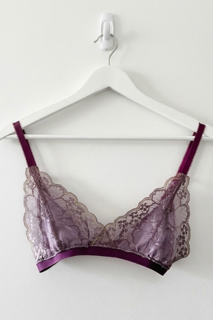 Cuurve Airy Aurora wire-free lace bralette in Dusk, handcrafted in London, triangle cup silhouette on white hanger against white wall