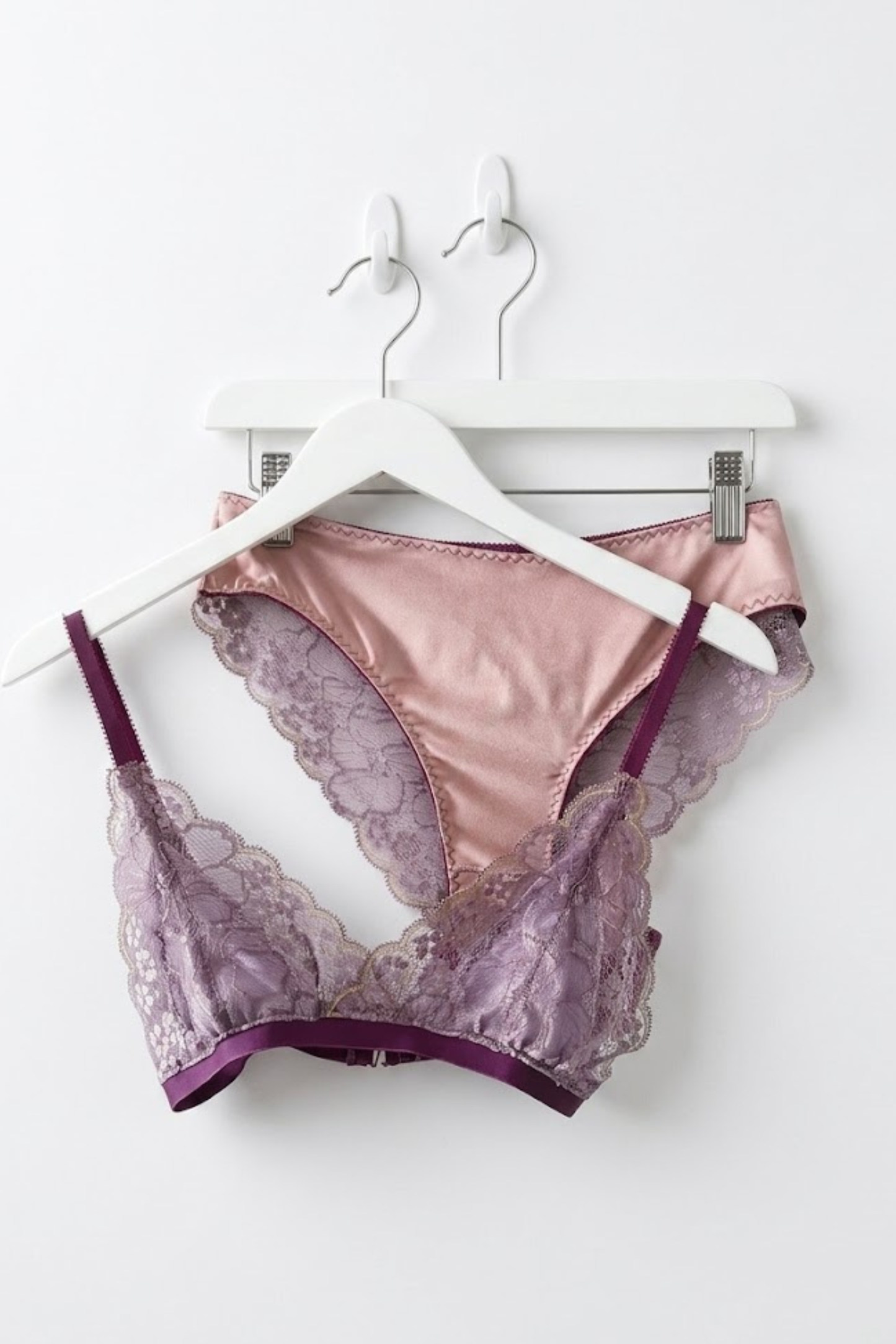 Cuurve Airy Aurora wire-free lace bralette in Dusk and Sleek Sophie brief in Dusk, matching lingerie set on white hanger against white wall