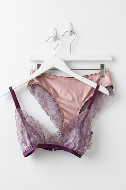 Cuurve Airy Aurora wire-free lace bralette in Dusk and Sleek Sophie brief in Dusk, matching lingerie set on white hanger against white wall