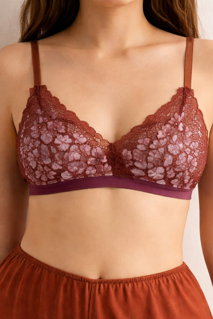 Close-up front view of an airy cocoa-lilac wire-free lace bralette with soft triangle cups, worn with spiced terracotta shorts. Lightweight, breathable, and gently supportive.