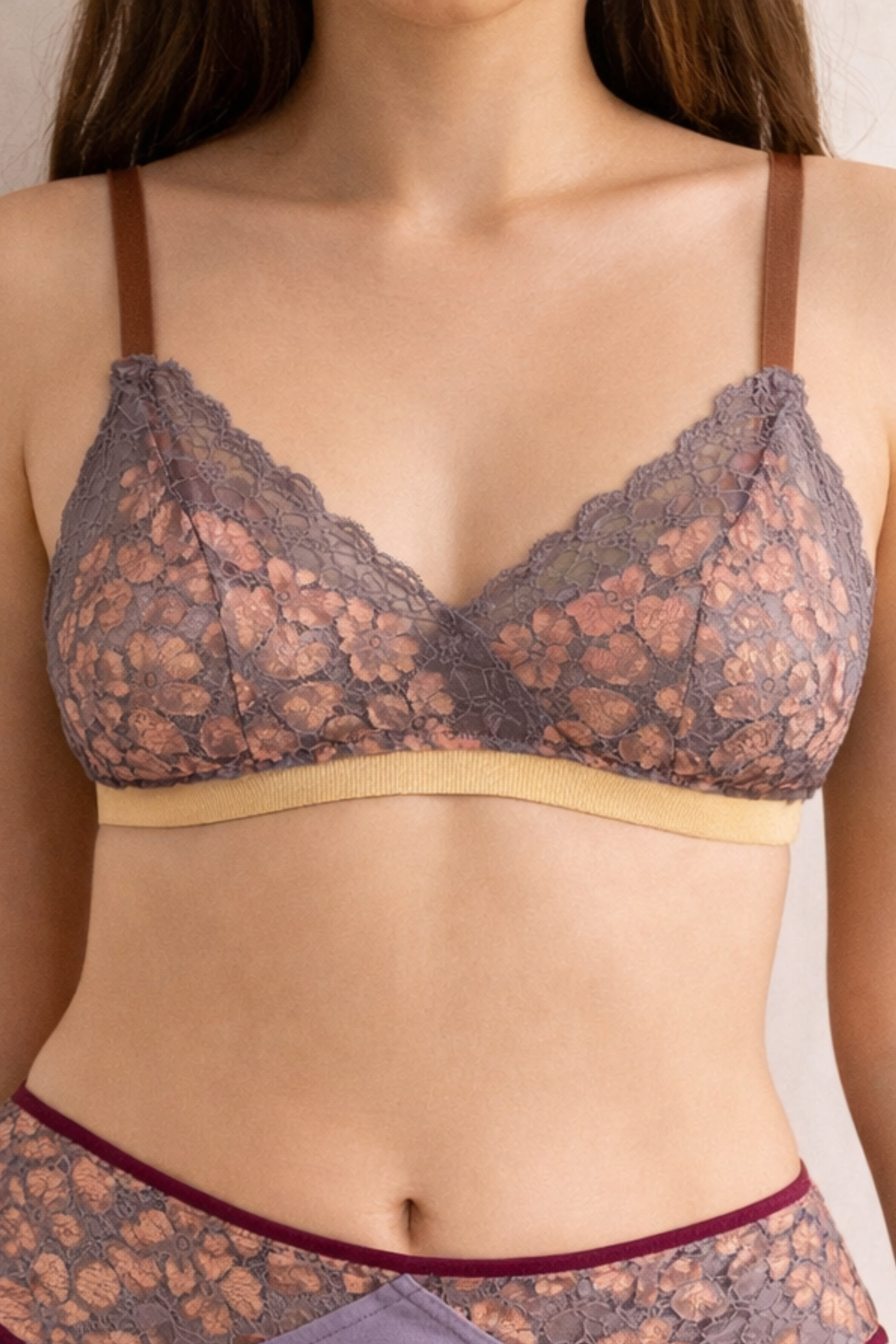 Front view of an airy metallic rose wire-free lace bralette with soft triangle cups and dual-tone shimmer lace, worn with matching lilac lace briefs.