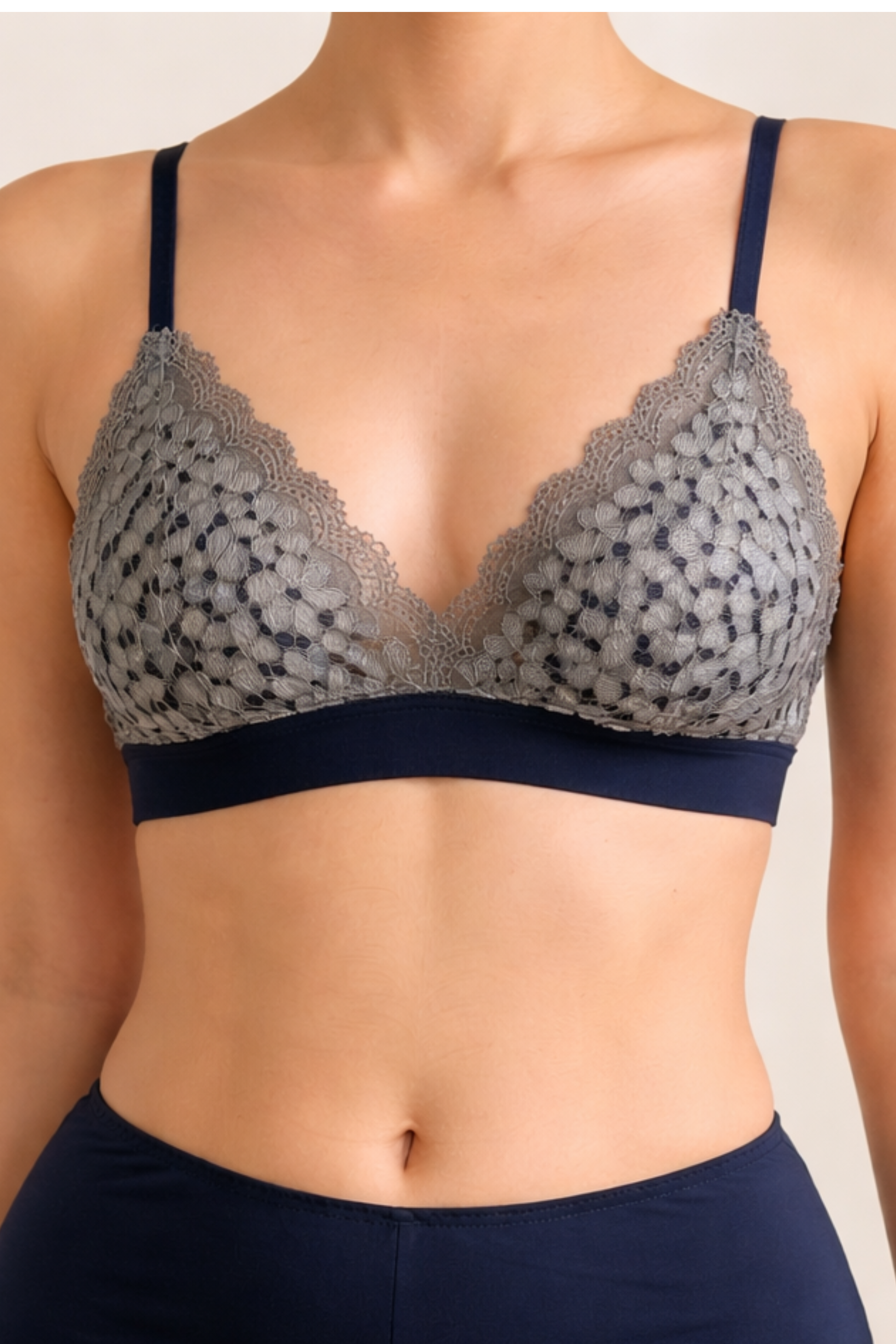 Front view of an airy navy wire-free lace bralette with soft triangle cups and delicate lace, designed for smaller busts.