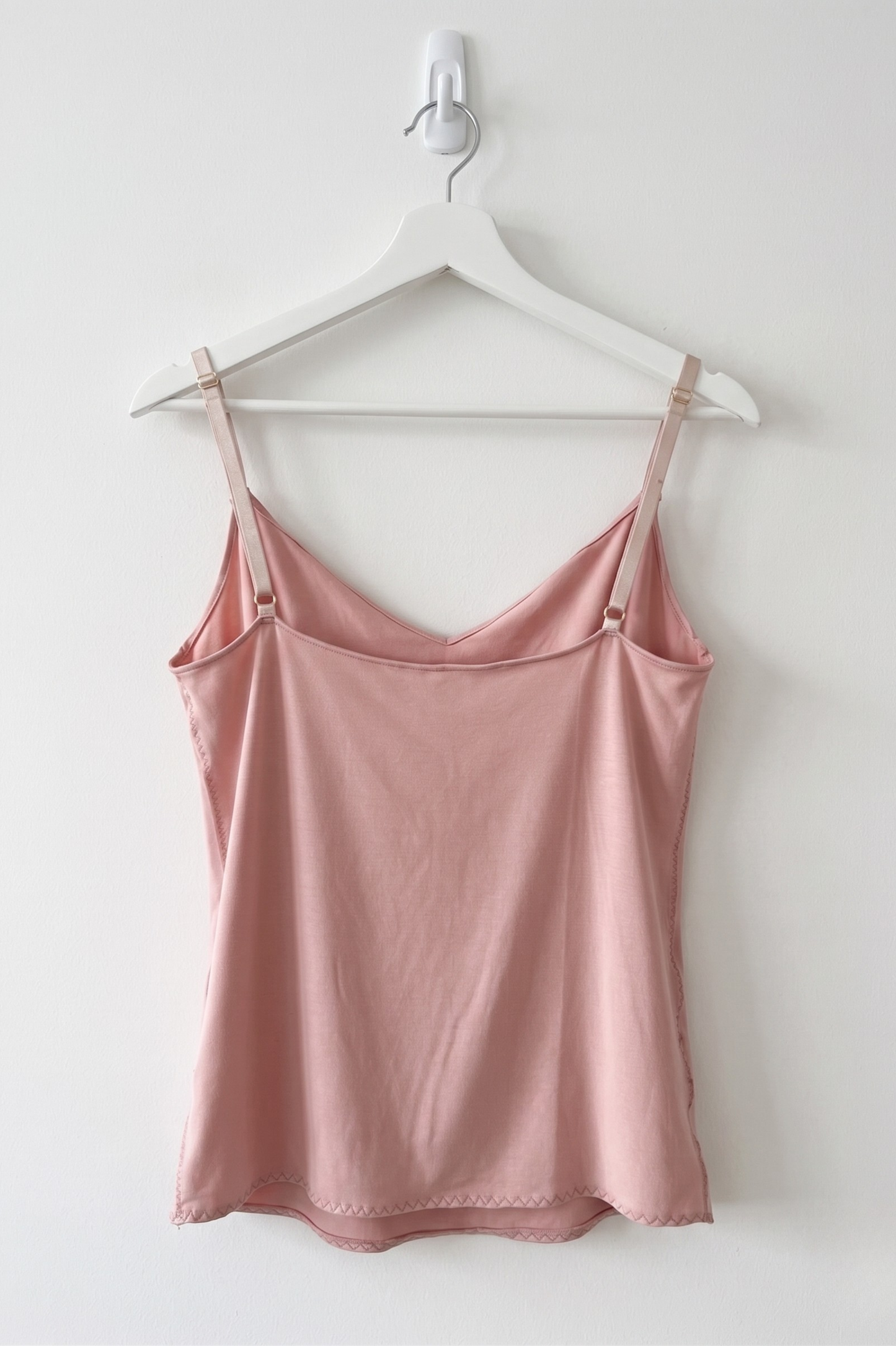 Cuurve Calm Clara cowl neck cami in Blush, soft modal jersey back view hanging on white hanger against white wall



Cuurve Calm