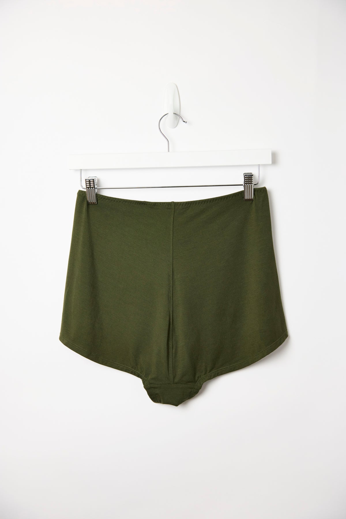 Dark olive Cosy Charlotte shorts hanging on a white clip hanger, closer view against a plain white background