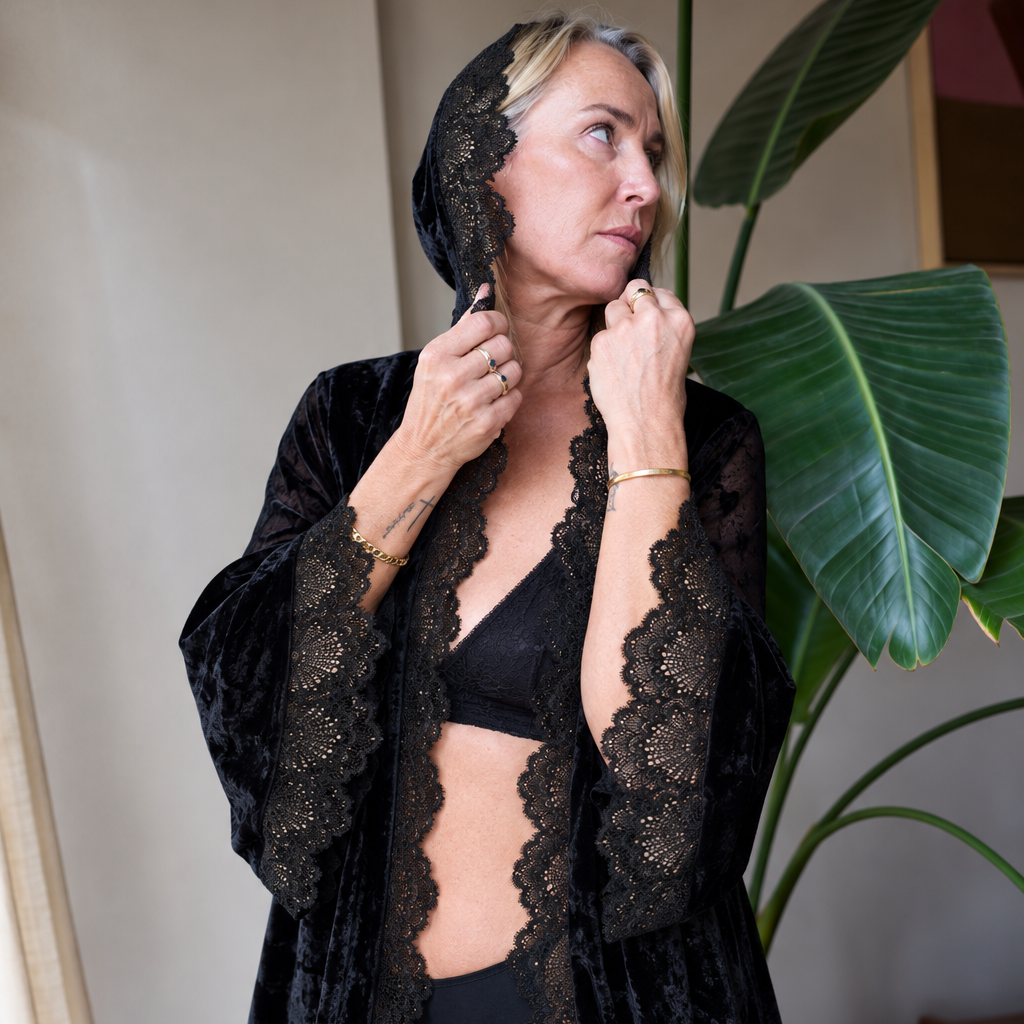 Model wearing the romantasy gown with the lace-edged hood up