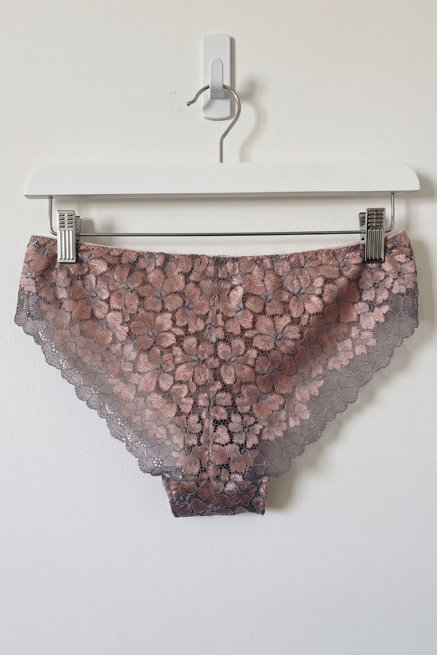 Lace underwear on a hanger against a white background