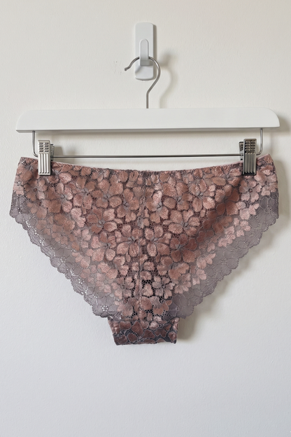Lace underwear on a hanger against a white background