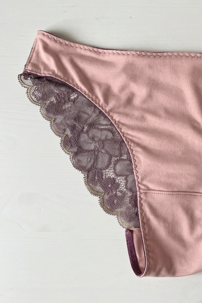 Handcrafted UK lingerie brief in blush pink and dusk lace, deep violet lace with gold trim detail, Cuurve Sleek Sophie,flat lay on a white table showing the trim detail 