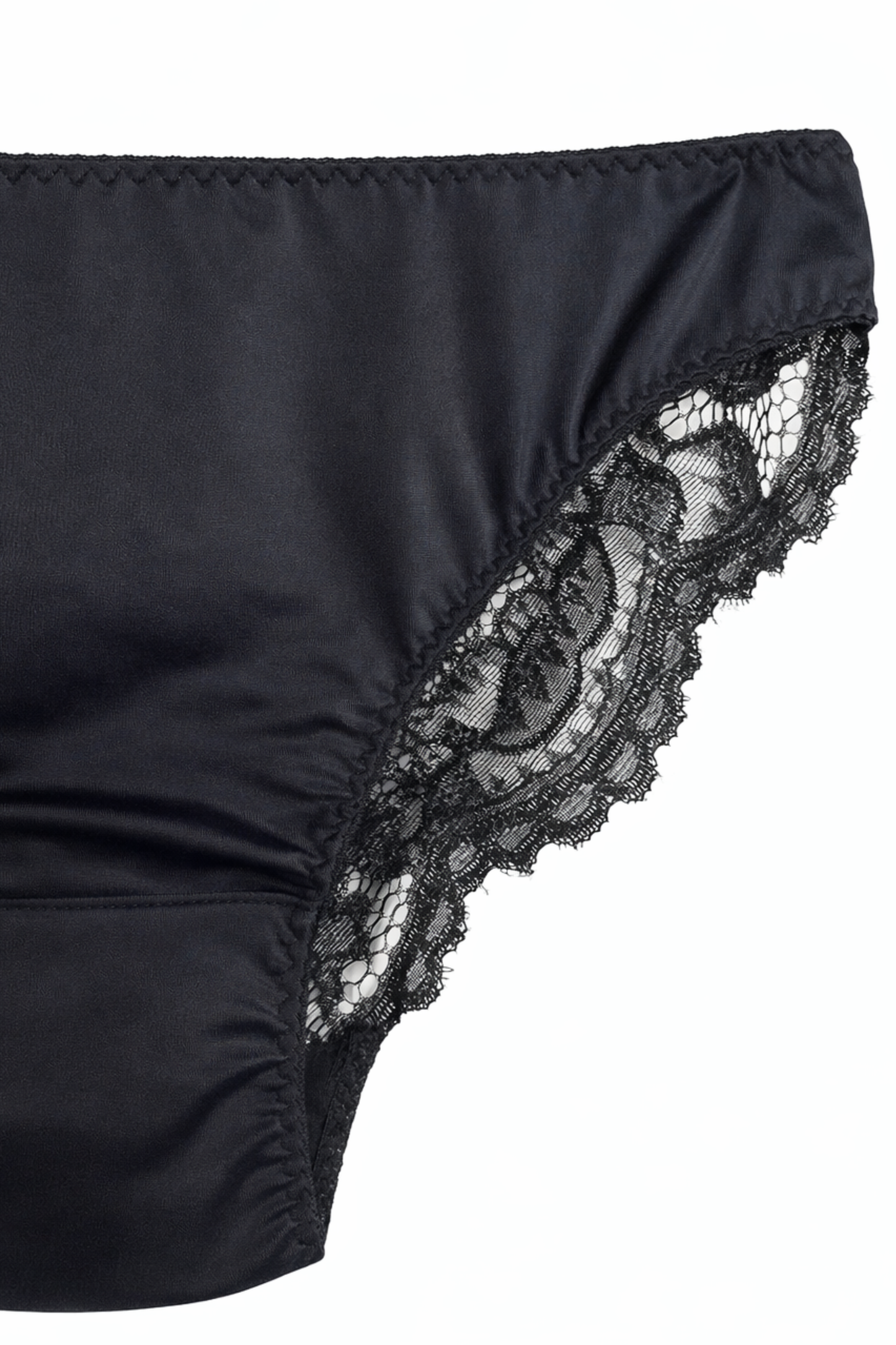 Close-up of soft floral lace with rounded scalloped edge on black low rise brief, lightweight and pressure-free lace for sensitive or swollen skin. Made in England