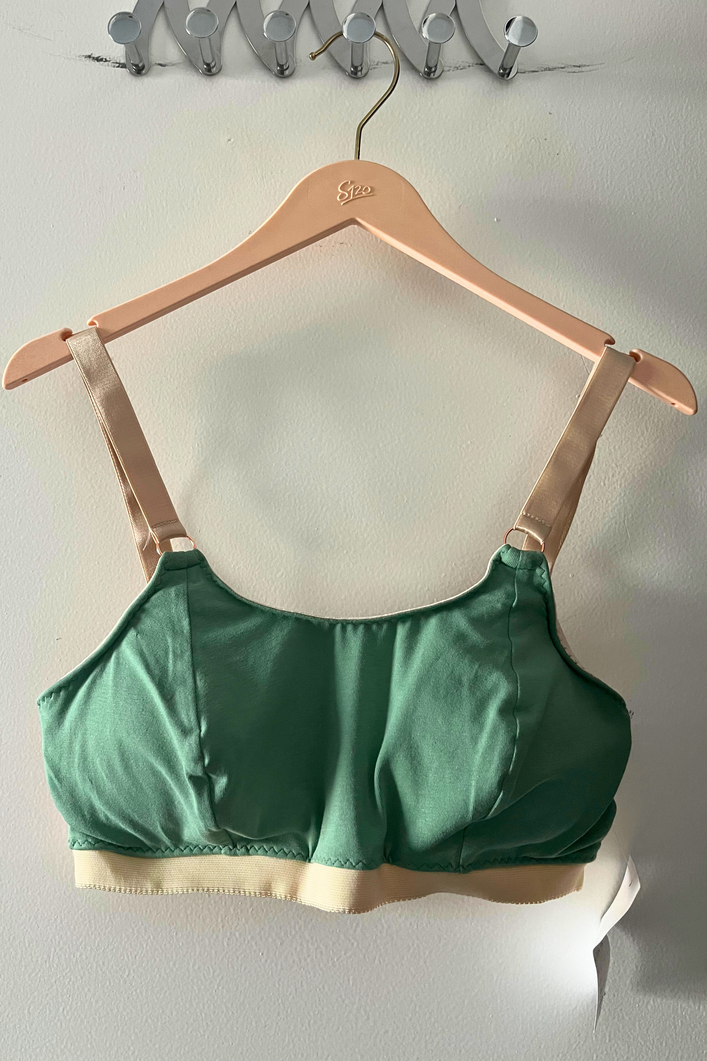 front view of the green dd+ bralette displaying the adjustable cross-back hooks, wide straps and supportive band.