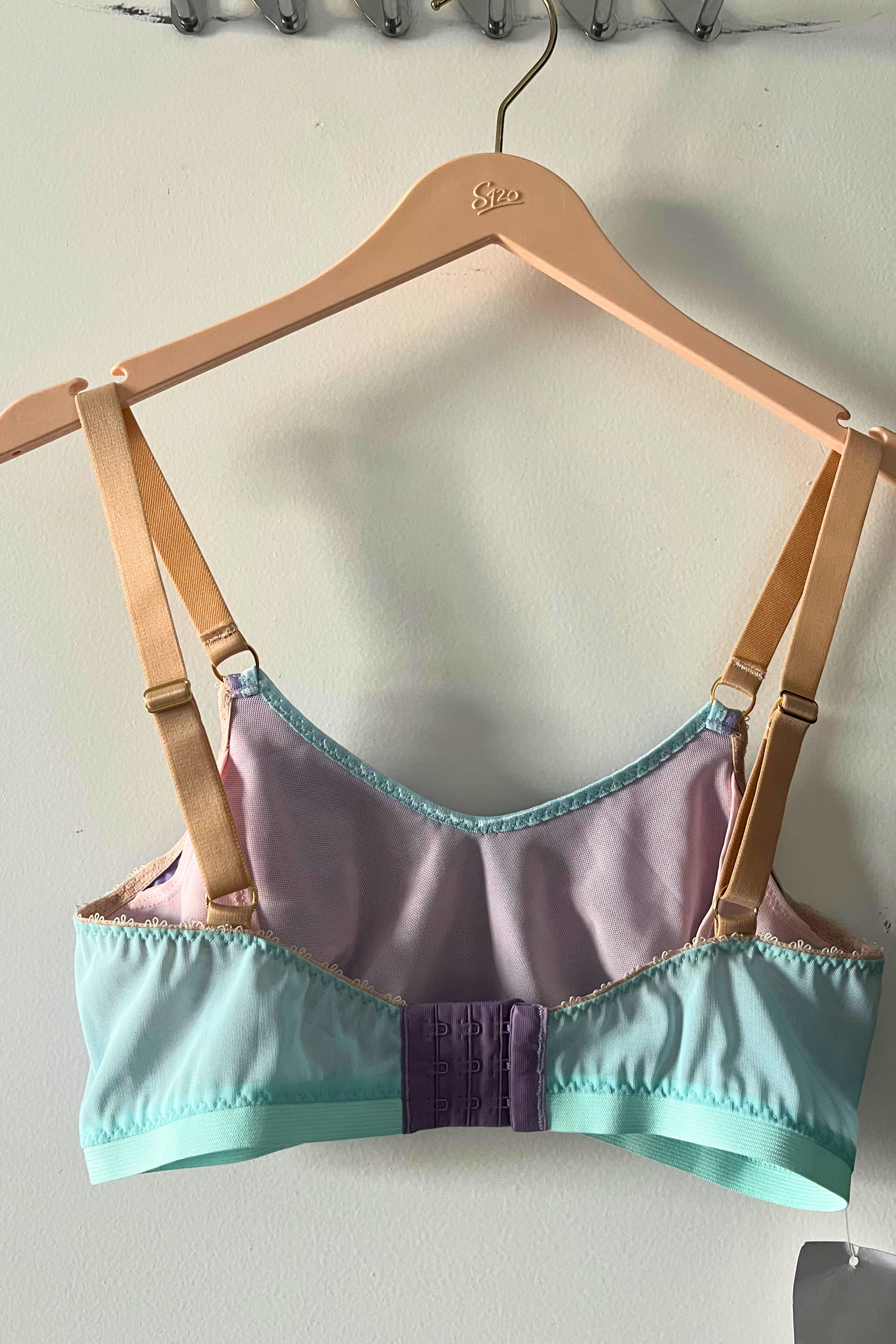back view of the lilac and aqua round-neck bralette with hook-and-eye closure, lilac jersey, and aqua mesh panel detailing.