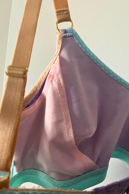 close-up side view of the round-neck bralette showing aqua mesh panel, lilac cotton jersey, and internal mesh sling area.
