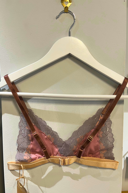 back view hand-sewn metallic rose lace bralette on a white hanger, highlighting the rose-gold hardware, super soft gentle comfort modal nipple covers soft lace texture and j-hook closure detail.